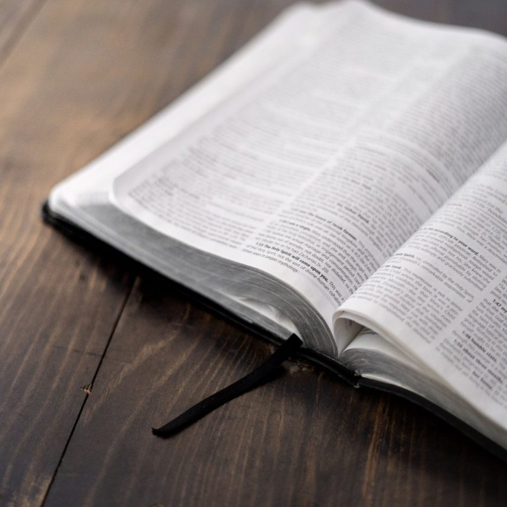 An open Bible on a wooden table